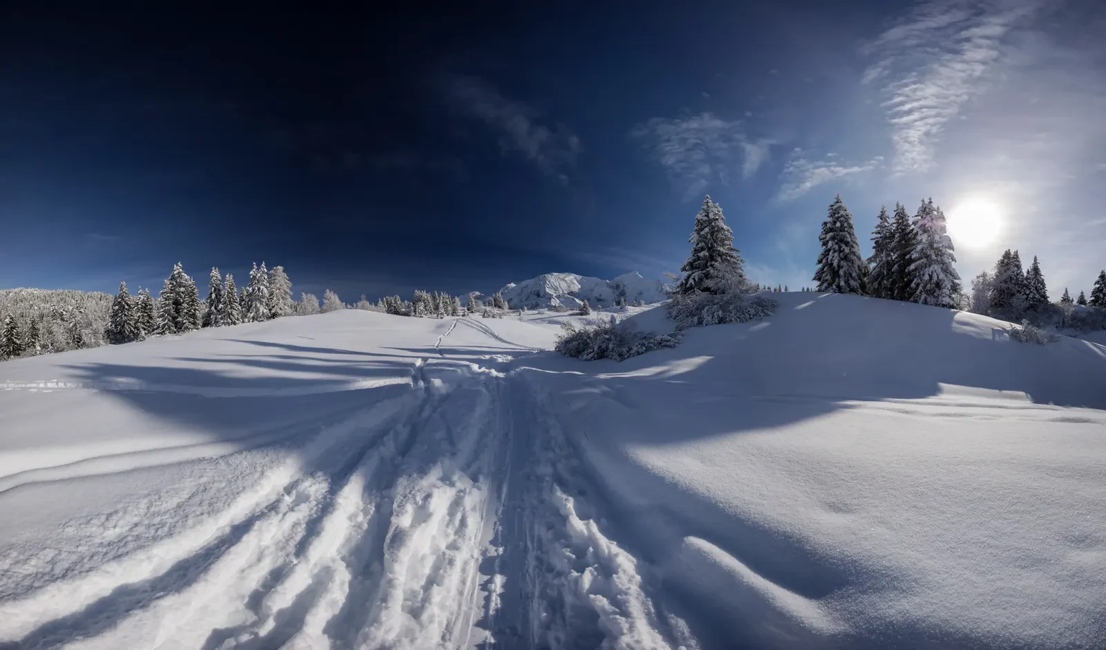 Uma vasta face alpina coberta de neve sob a luz clara do inverno